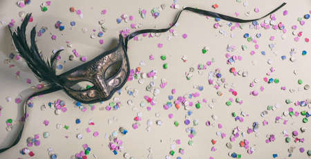 Carnival party. Venetian mask and confetti on pastel grey background, top view, copy spaceの写真素材