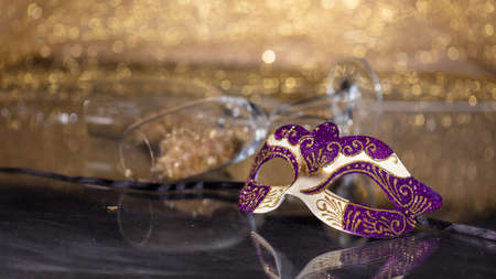 Carnival time. Venetian mask on golden bokeh background, reflections, copy spaceの写真素材