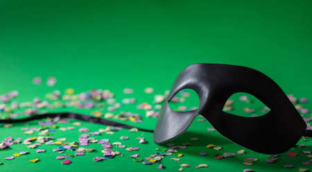 Carnival party. Venetian mask and confetti on green background, copy spaceの写真素材