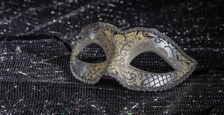 Carnival time. Venetian mask on black shiny background, closeup viewの写真素材