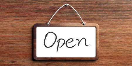 Open, handwritten text. Sign with red frame hanging on on wooden wall. 3d illustrationの写真素材