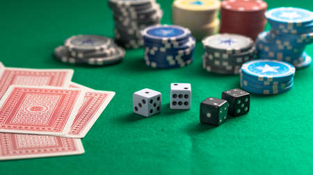Casino, gambling concept. Poker chips piles, playing cards and dice on green felt backgroundの写真素材