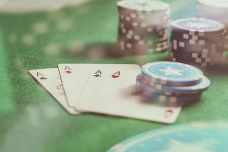 Casino, betting, concept. Four aces and poker chips on green felt abstract background