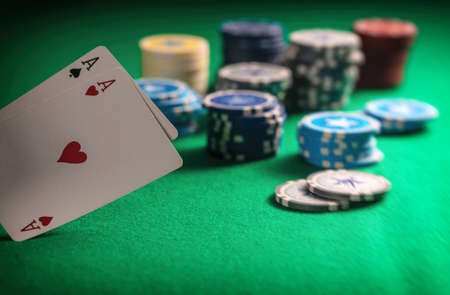 Casino, gambling concept. Two aces and poker chips on green felt background