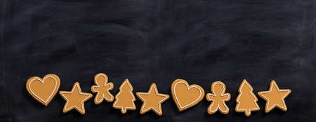 Christmas preparation, gingerbread cookies. Top view of christmas gingerbread cookies, isolated, against blackboard, border, copy space, banner. 3d illustrationの写真素材