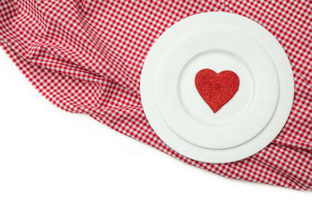 Valentines day dinner, table, place setting. Red heart on white plates, red checkered table cloth, white background, copy space, top view.の写真素材