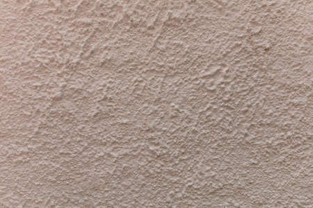 Beige color, plaster grainy style wall texture background. Exterior facade of a residential building