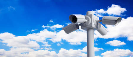 Security Cameras CCTV system. Surveillance cams on pole on blue sky background, banner, copy space. 3d illustrationの写真素材