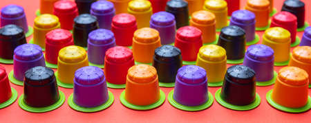 Coffee capsules compostable. Colorful espresso pods, eco friendly, aluminum free with green ring on orange color backgroundの写真素材