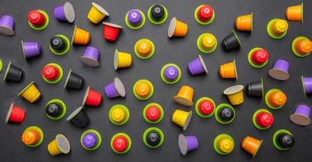 Coffee capsules compostable. Colorful espresso pods, eco friendly, aluminum free with green ring on black color backgroundの写真素材