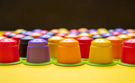Coffee capsules compostable. Colorful espresso pods, eco friendly, aluminum free with green ring on yellow and black color background, bannerの写真素材