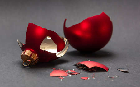 Christmas accident. Red Christmas ball broken, dark gray background, closeup viewの写真素材
