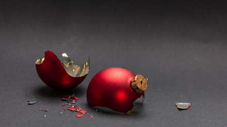 Christmas accident. Red Christmas ball broken, dark gray background, closeup viewの写真素材