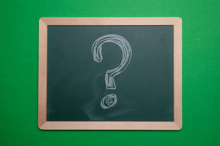Question mark. Chalk hand drawing question mark shape on green board with wooden frame backgroundの写真素材