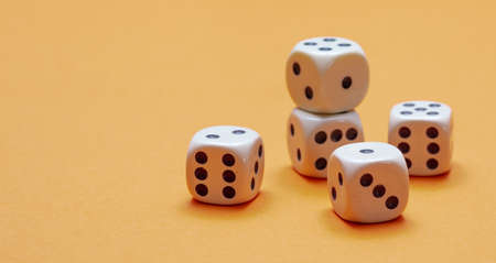 Dice on orange color background, copy space, front view