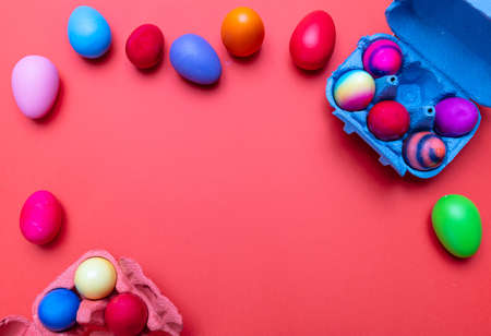 Easter eggs, pastel colors painted and a carton case, orange color background, copy space, top view