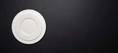 Set of empty white plates on black color background, banner, top view, copy spaceの写真素材