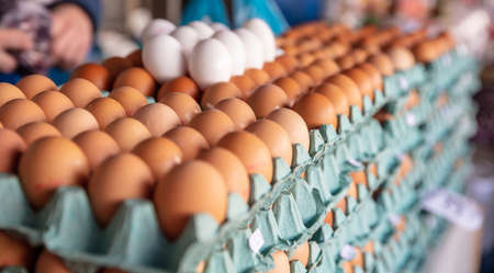 Chicken eggs in the market. Carton packages with eggs stacked background, texture. Closeup view