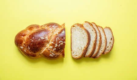 Easter preparation. Tsoureki braid, greek easter sweet bread sliced on yellow color background, top viewの写真素材