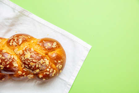 Easter preparation. Tsoureki braid, greek easter sweet bread on white tablecloth, green color...