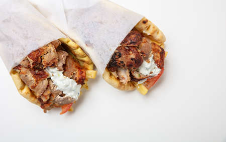 Gyro pita, shawarma, take away, street food. Two pita bread wraps with meat, traditional greek turkish food on white backgroundの写真素材