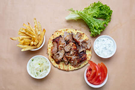 Gyro pita ingredients. Shawarma, gyros, pita bread, vegetables and tzatziki sauce, top view. Traditional turkish, greek meat food.の写真素材