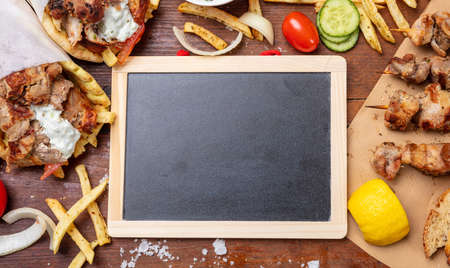 Gyro pita, shawarma. Two pita bread wraps with meat, and blank board on wooden table, space for textの写真素材