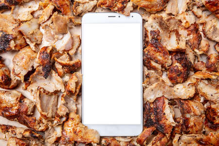 Shawarma, gyros, online order. Traditional turkish, greek meat food and a mobile phone with blank...