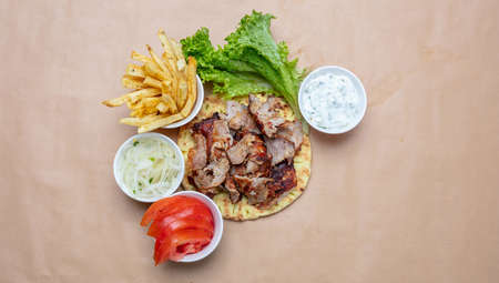 Gyro pita ingredients. Shawarma, gyros, pita bread, vegetables and tzatziki sauce, top view, copy space. Traditional turkish, greek meat food.の写真素材