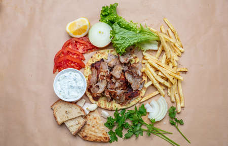 Shawarma, gyros on pita bread, vegetables and tzatziki sauce, top view. Traditional turkish, greek meat food.の写真素材