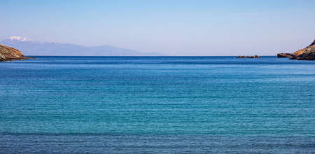 Greece. Aegean sea. Blue sky, calm turquoise sea water and snowed mountains.の写真素材