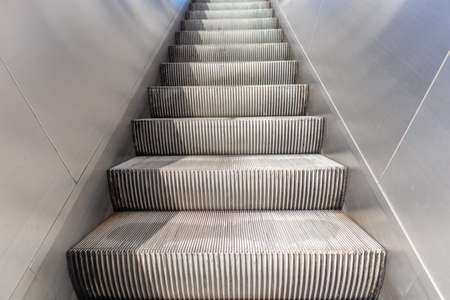 Empty and clean electric escalators going up, stainless steel finishings, closeup viewの写真素材