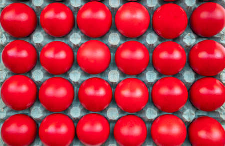 Orthodox Easter. Red eggs in carton packaging, top view, full background