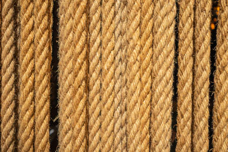 Vertical ropes, tether in row background. Brown twisted cord backdrop. closeup viewの写真素材
