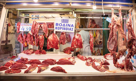 April 28, 2019. Athens, Greece. Raw beef in a row out of a butcher shop. Cow meat in big pieces hangs from hook ready to be sold. Store background.のeditorial素材