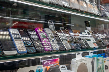 April 28, 2019. Athens, Greece. Phones new and retro through shop's showcase. Telephones evolution from keypad to touchpad on store's shelves.のeditorial素材