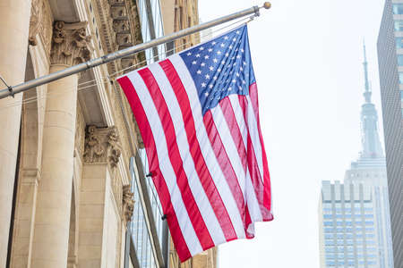 USA symbol in New York streets. American flag on a building, Manhattan downtown, blur Empire state building on the backgroundの写真素材