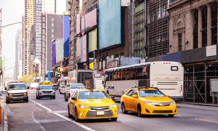 New York, Manhattan streets. Skyscrapers, colorful signs and ads, cars and taxi cabs