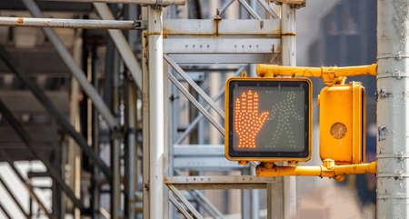 Stop, dont walk red hand traffic signal for pedestrians in New York city center, blur metal structure background, closeup view, copy spaceの写真素材