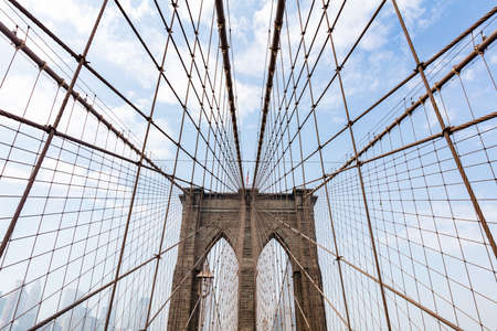 Brooklyn Bridge upper part detail against blue cloudy sky background. New York city, Manhattan landmarkの写真素材
