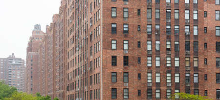 New York, Manhattan Chelsea area. Brick wall facade skyscrapers against cloudy sky background. View...