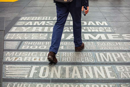 USA, New York, Times Square. May 2, 2019. List of theaters names and map on the ground. Ma walking on itのeditorial素材