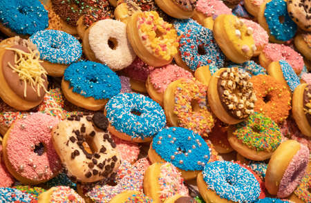 Assorted donuts, bakery display. Colorful donuts assortment background. Close up view