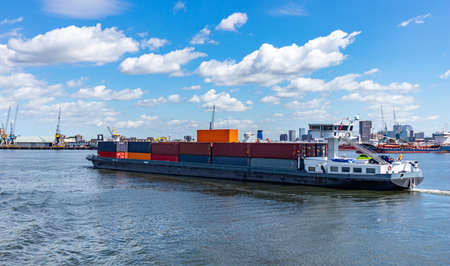 Water transport, export, import and logistics business. Container ship at international commercial harbor of Rotterdam Netherlands, sunny summer dayの写真素材