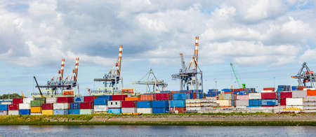 Logistics business panorama. Stacked containers and huge bridge cranes, international port of Rotterdam Netherlands, sunny summer day, bannerの写真素材