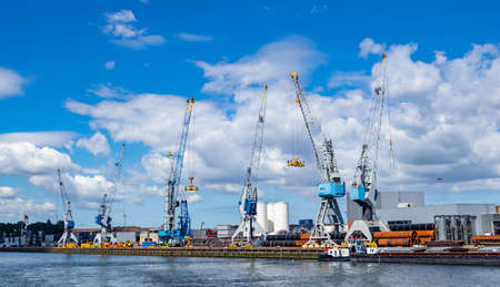 Import export logistics business. Huge cranes and pipes at international port of Rotterdam Netherlands, sunny summer dayの写真素材
