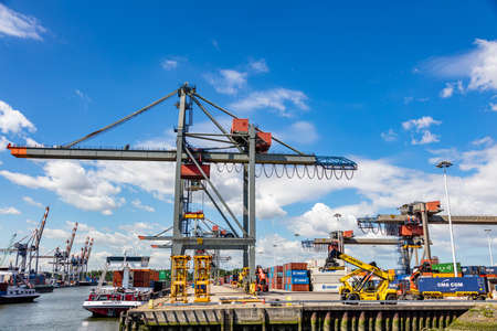 Rotterdam harbor, Netherlands. July 2nd, 2019. Logistics business. Huge cranes and ships anchored at International commercial port, sunny summer dayのeditorial素材