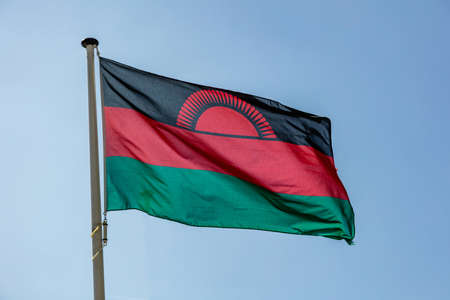 Malawi flag, Malawi national symbol waving against clear blue sky, sunny dayの写真素材