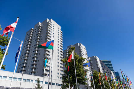Flag parade, Rotterdam, Netherlands. National symbols waving on poles, Highrise buildings and clear...