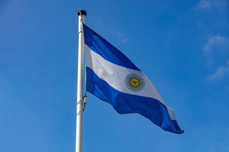 Argentina flag, Argentinian national symbol waving against clear blue sky, sunny dayの写真素材